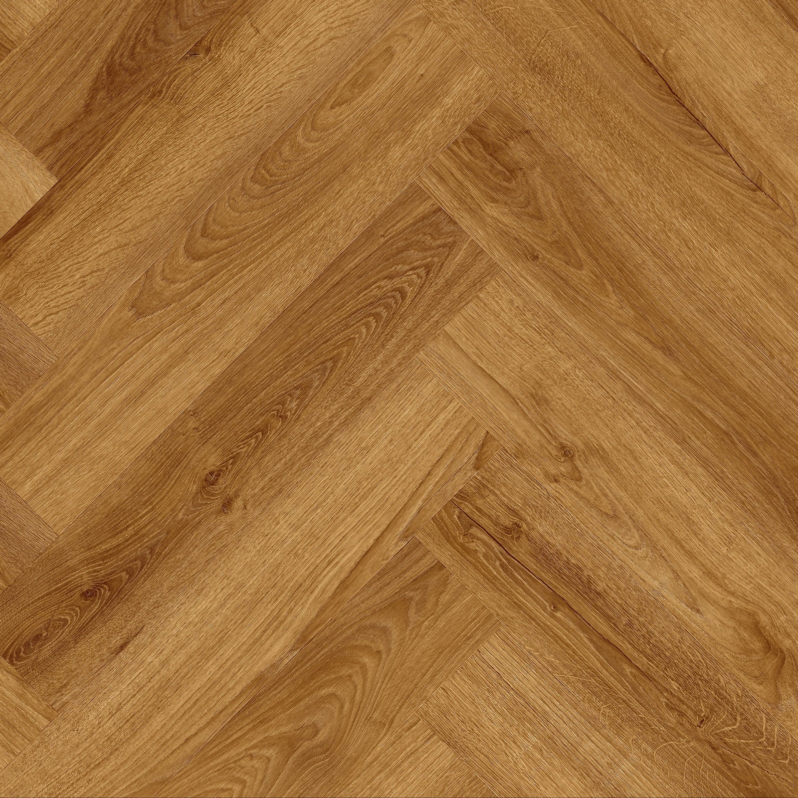 A close-up view of a herringbone wood flooring sample, showing the grain and texture of light brown oak planks arranged in a herringbone pattern.